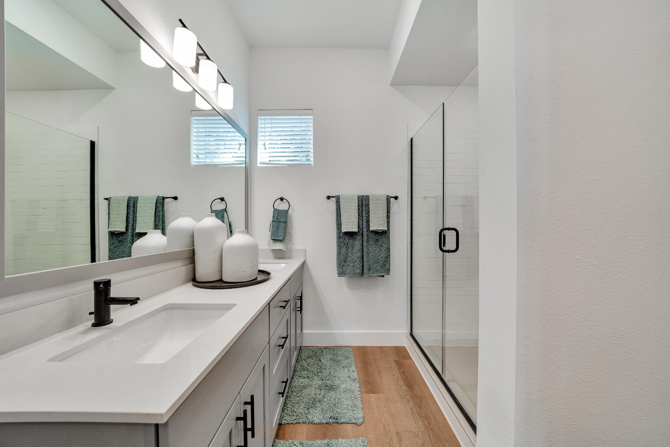 Large modern bathroom with a large mirror and sink inside a home at The parcHAUS at Mustang Drive