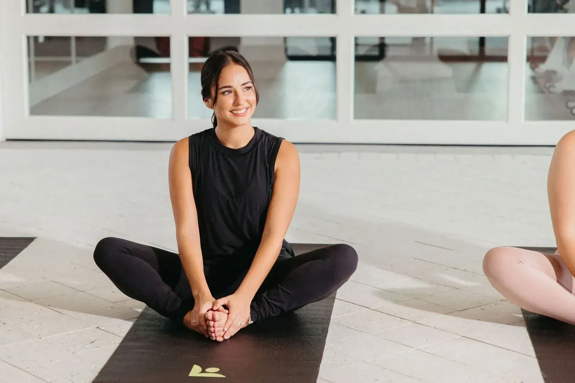 A woman is sitting on a yoga mat at Livano Wildwood