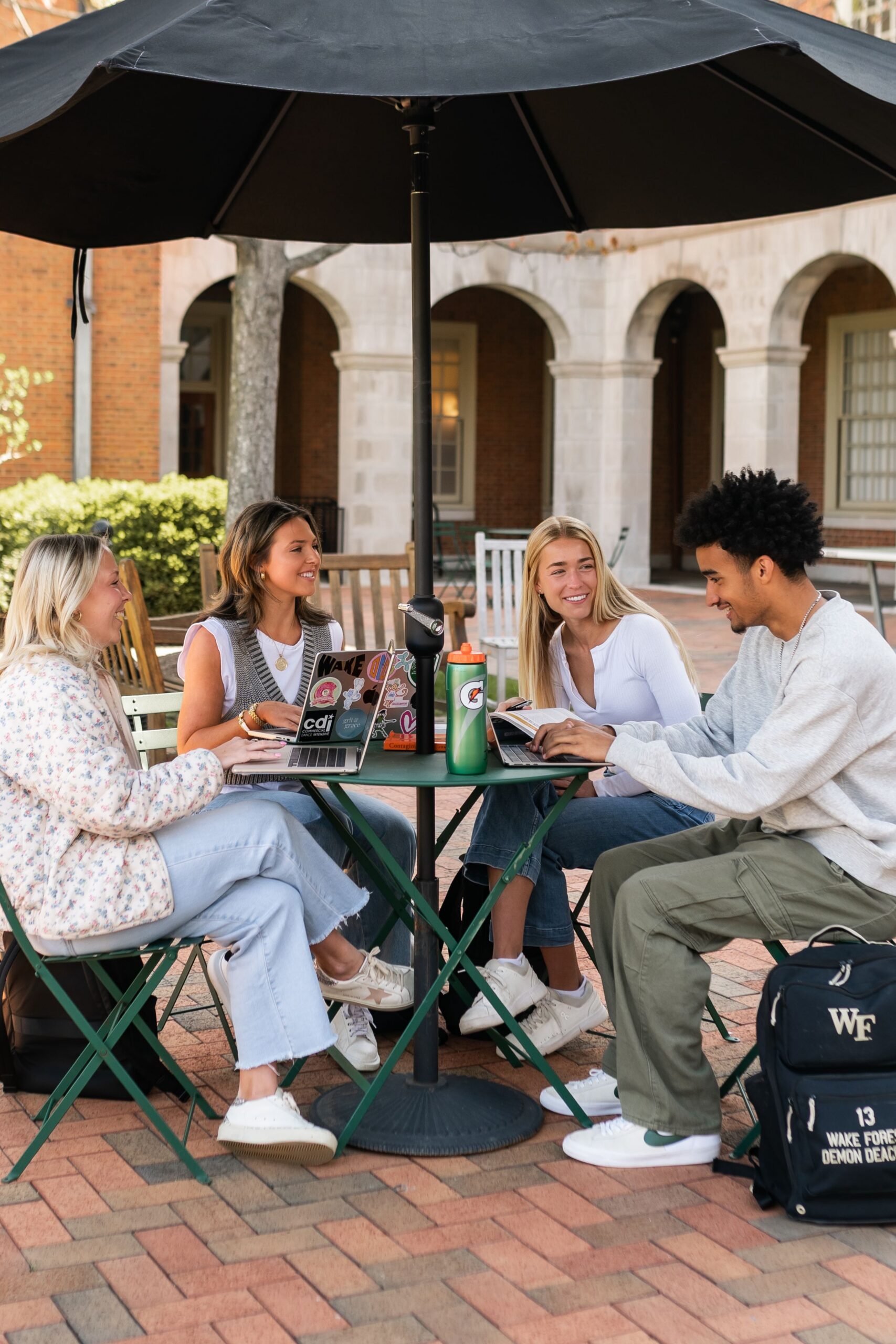 university peers reviewing coursework at courtyard scaled