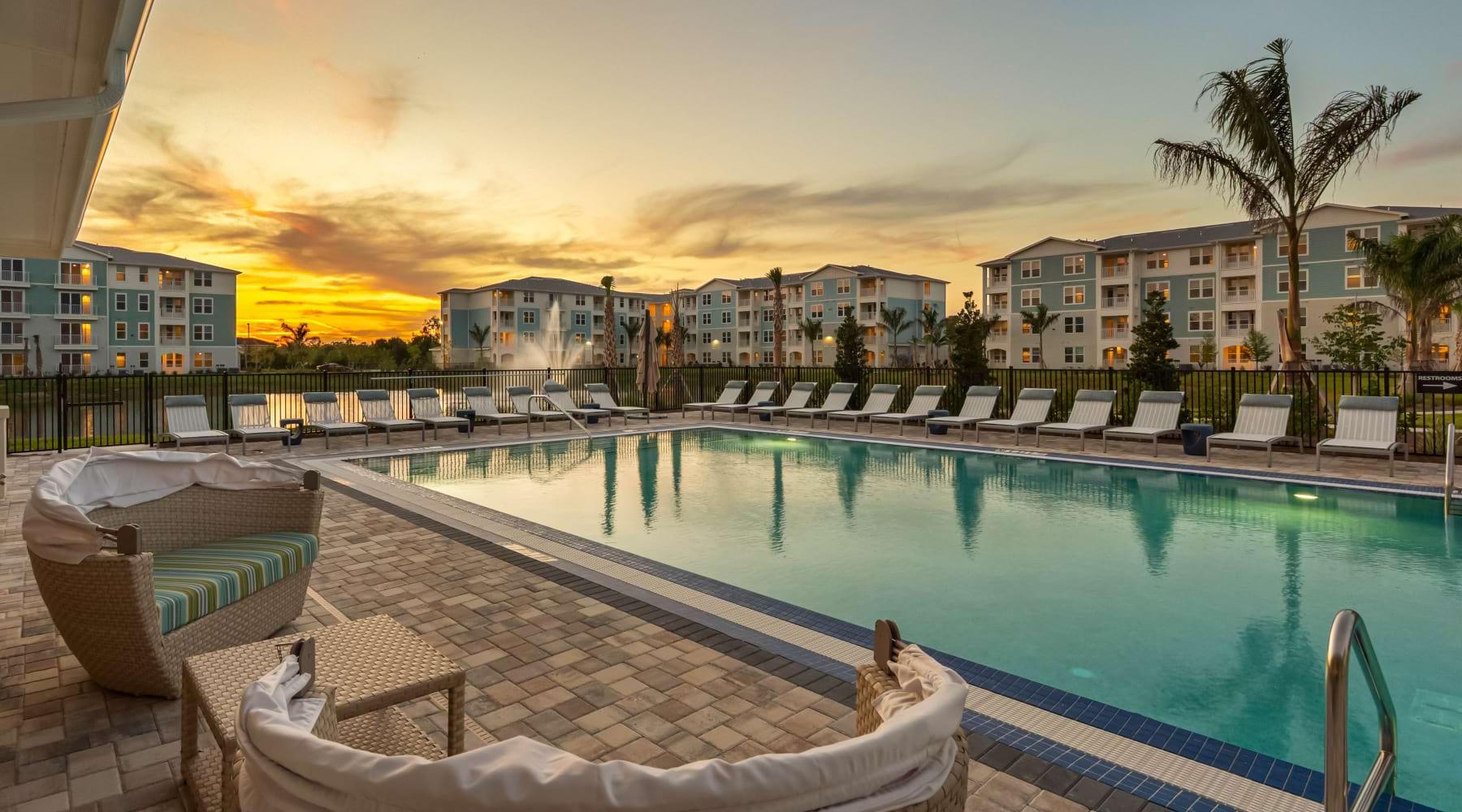 beautiful pool scene at sunset with a fountain lake in the background