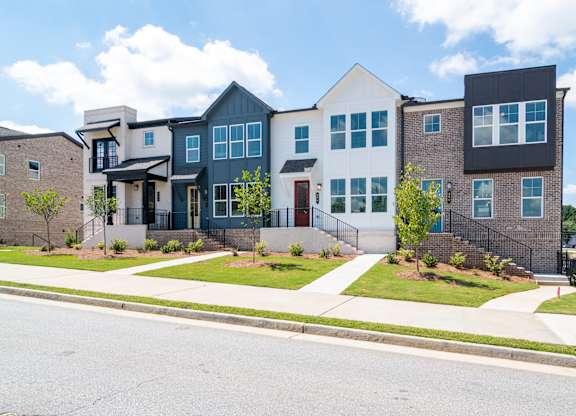 A row of modern houses with a white and black one in the middle.