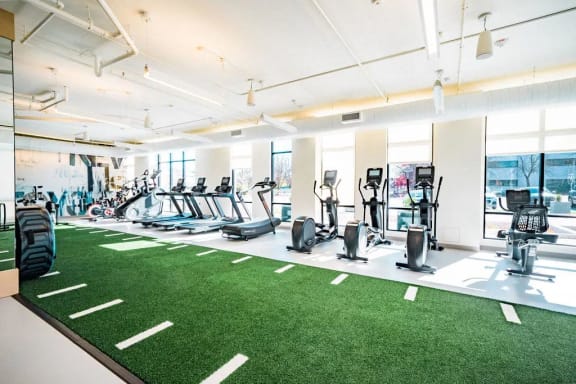 a gym with various cardio equipment and astroturfing grass