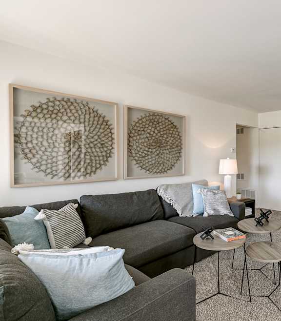 A modern living room with a blue couch and a coffee table. at DonCaster Village Apartments, Parkville, MD, 21234