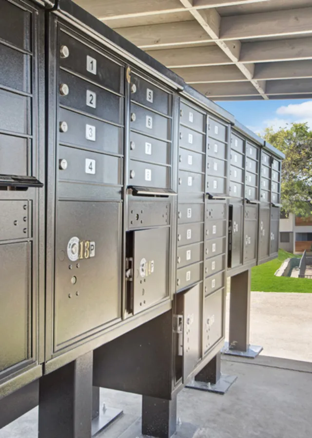 Modern and secure apartment complex mailboxes with a sleek black design, set in a well-maintained outdoor space.