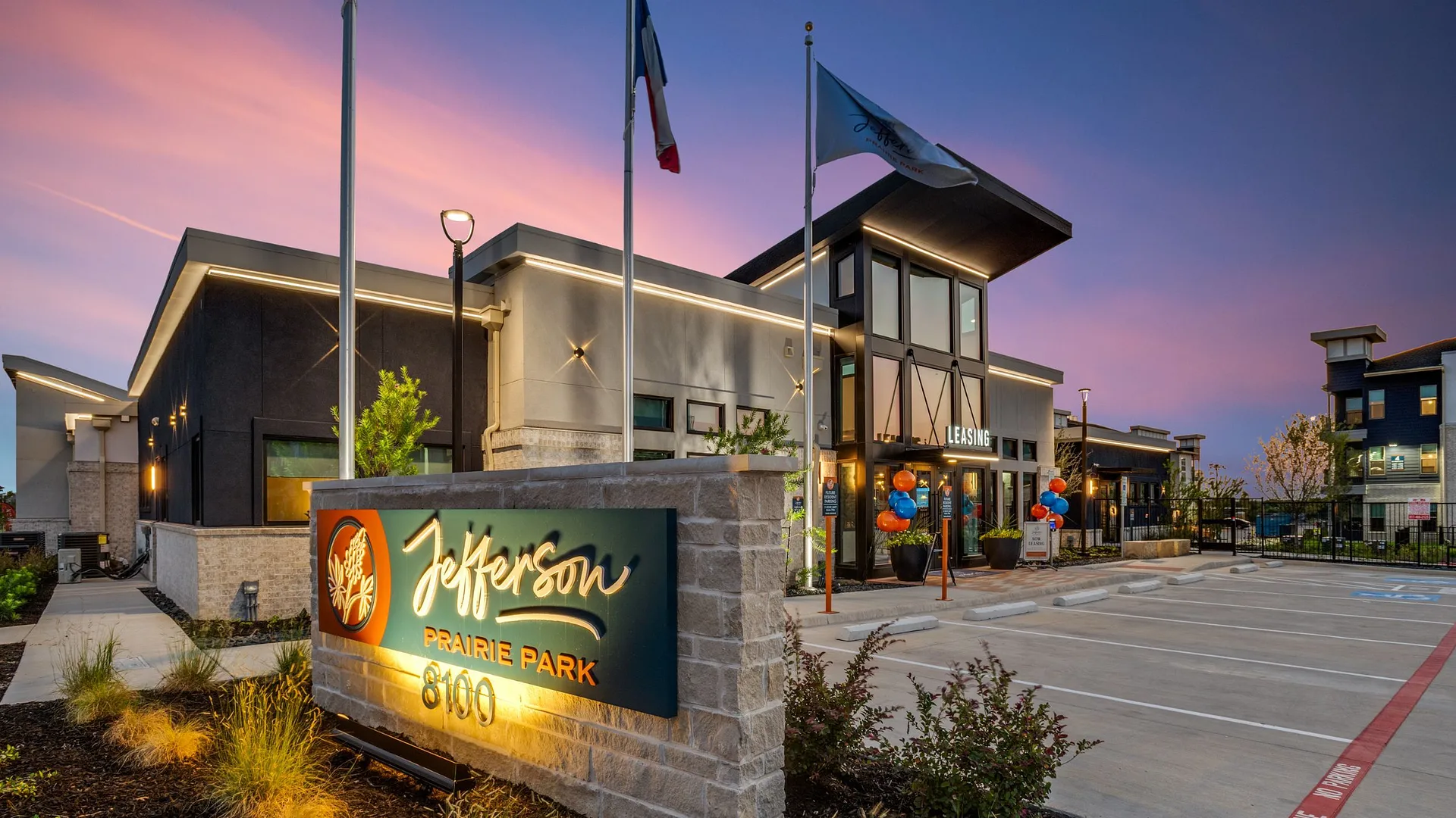 New apartment complex at sunset with welcoming decorations.