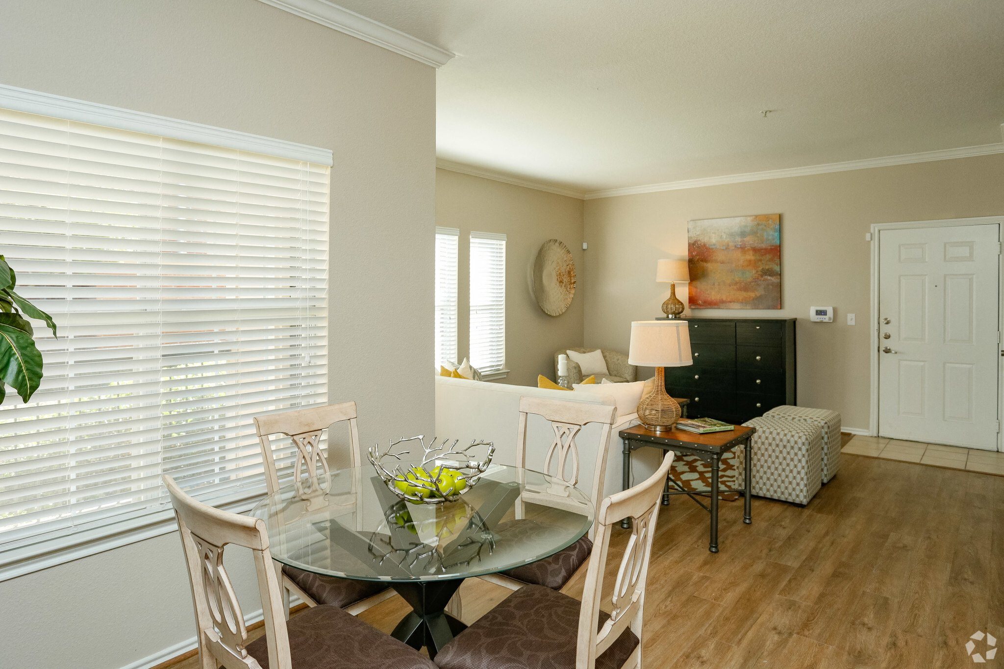 A dining room with a glass table and chairs.