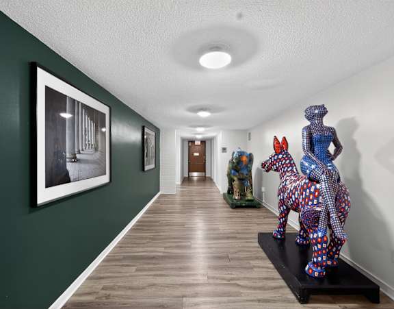 A hallway with a green wall and a framed black and white photo on the wall.