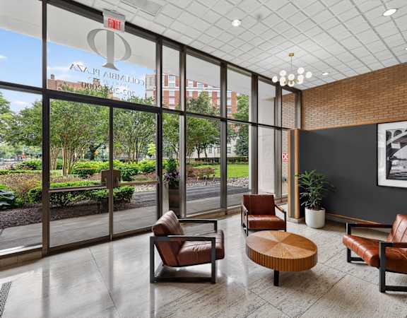 A waiting room with leather chairs and a view of the outside.