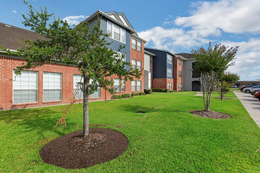 Stylish brick apartment building with plenty of green space at Humble Memorial Gardens