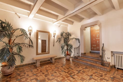 a lobby with a mirror and potted plants