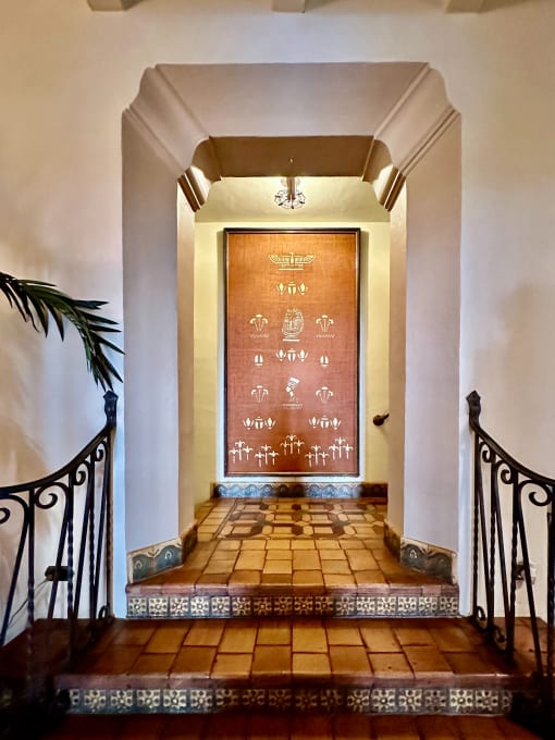 the entrance to the house is decorated with a large painting on the wall and stairs