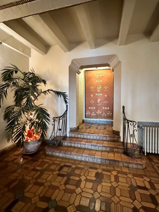 a hallway with a staircase and a potted plant and a door