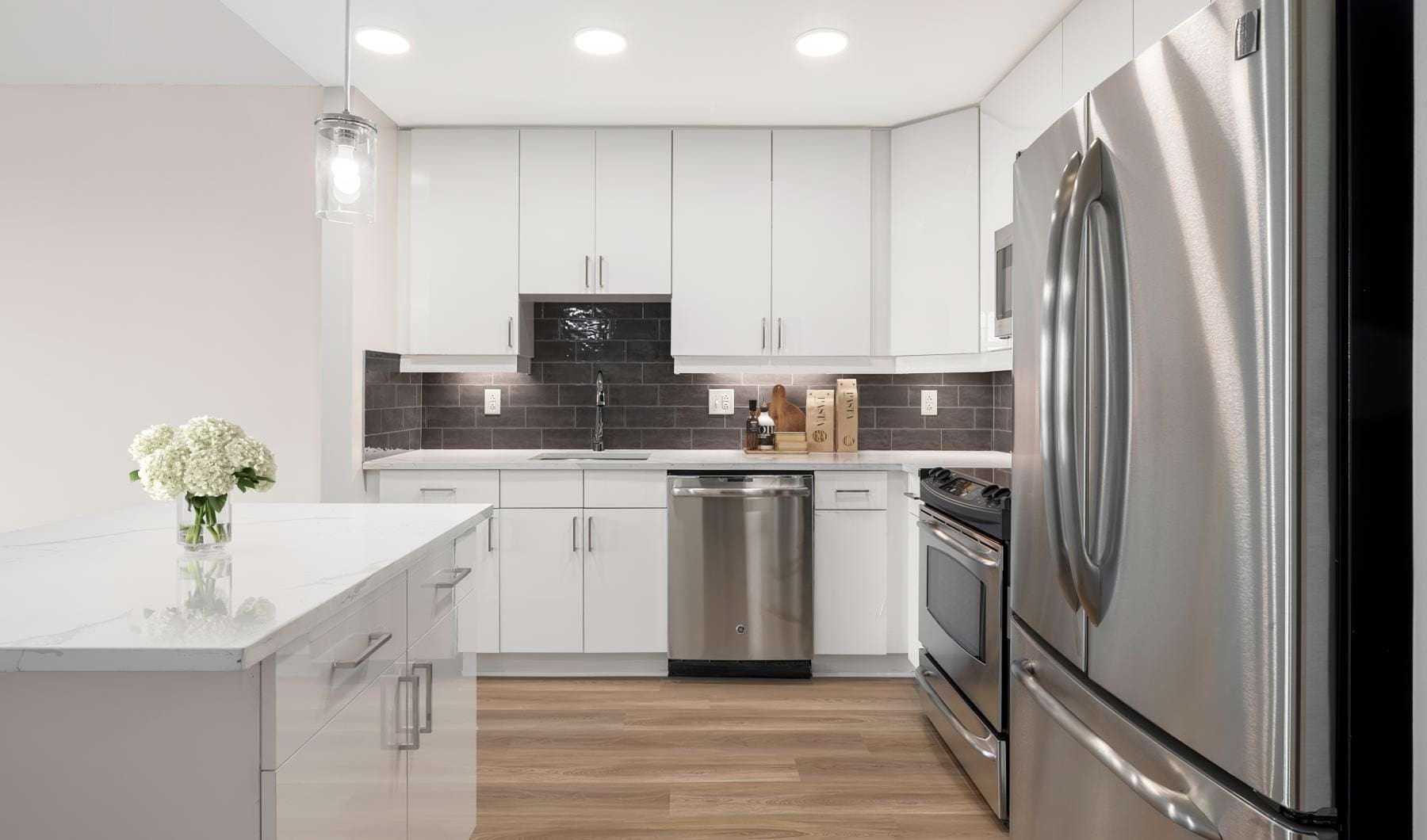 Kitchen with white cabinets and dark backsplash tile at Senate Square apartments in Washington, DC.