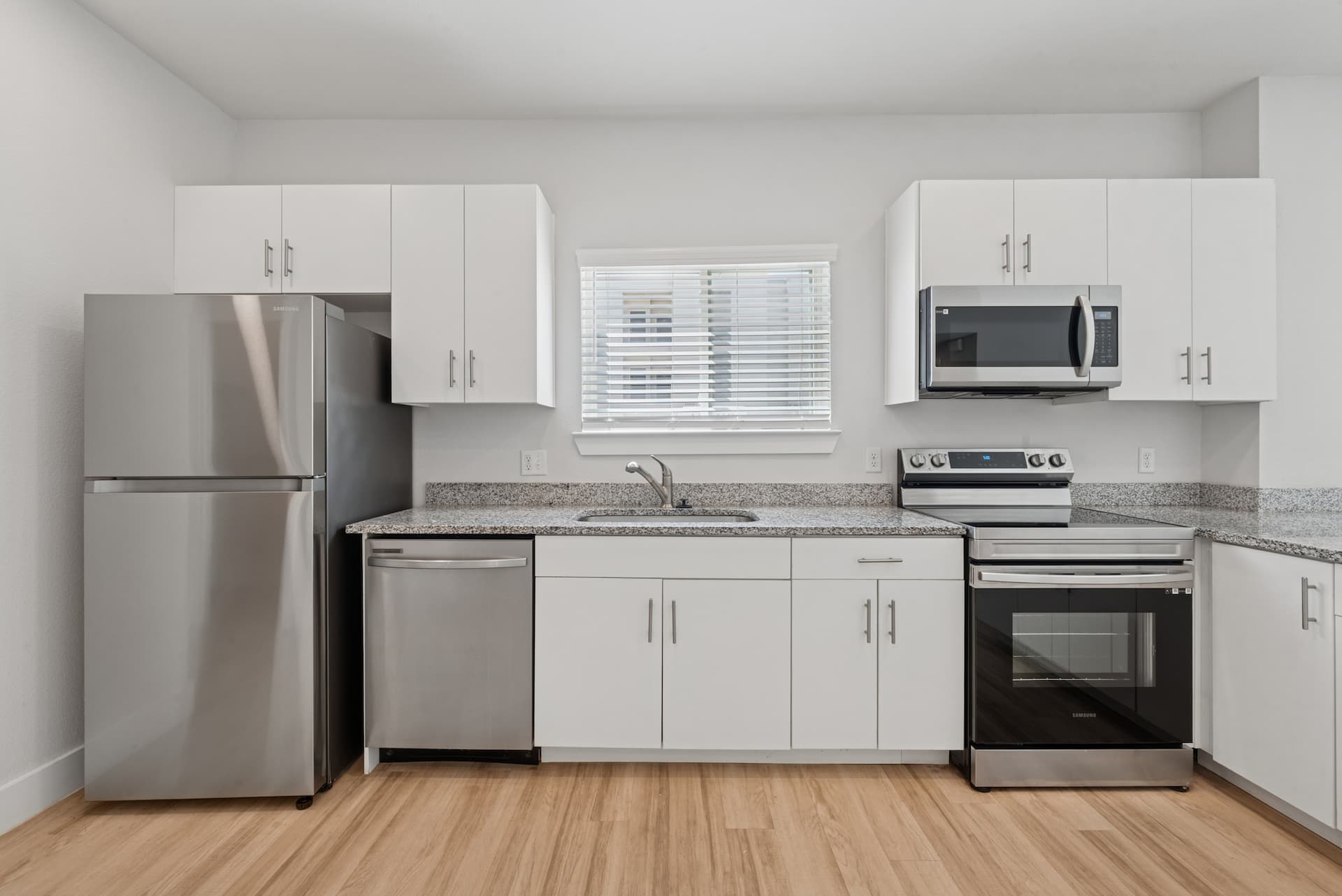 Straight-on kitchen view with granite countertops and stainless steel appliances.