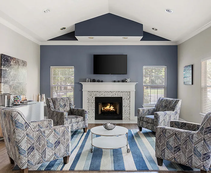 Inviting living room with cozy fireplace, patterned armchairs, and chic decor, perfect for relaxation and gatherings.