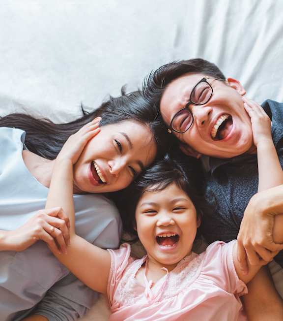 A family laughing in a bed at The Remington, Kentucky, 40511