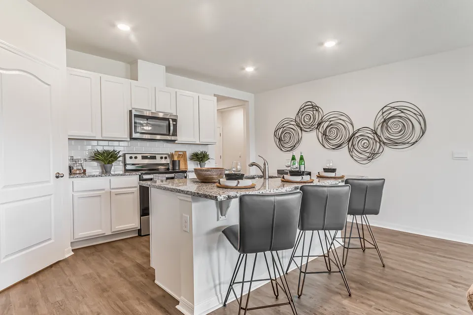Modern kitchen with sleek granite countertops, elegant bar seating, and contemporary decor, offering a perfect blend of style and functionality.