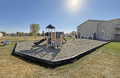A playground with a slide and a wooden structure.