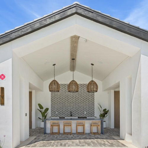 an outdoor community kitchen with chairs