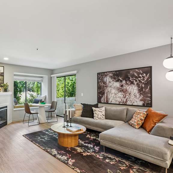 A living room with a grey couch, a coffee table, and a fireplace.