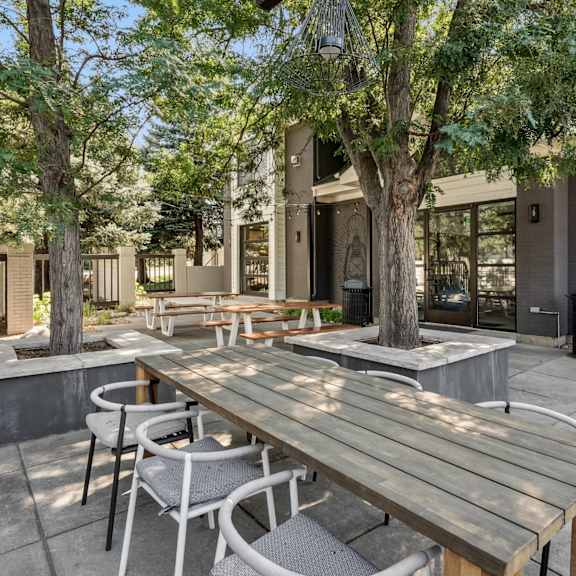 A patio with a table and chairs under a shade sail.