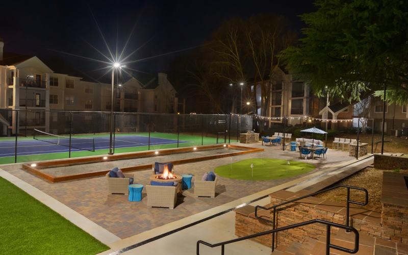 sport courts beside a firepit seating area at night