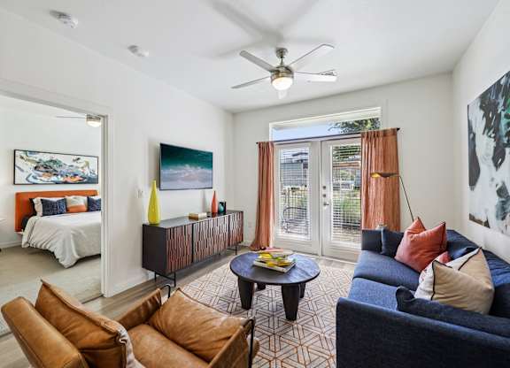 A living room with a brown couch and a ceiling fan.