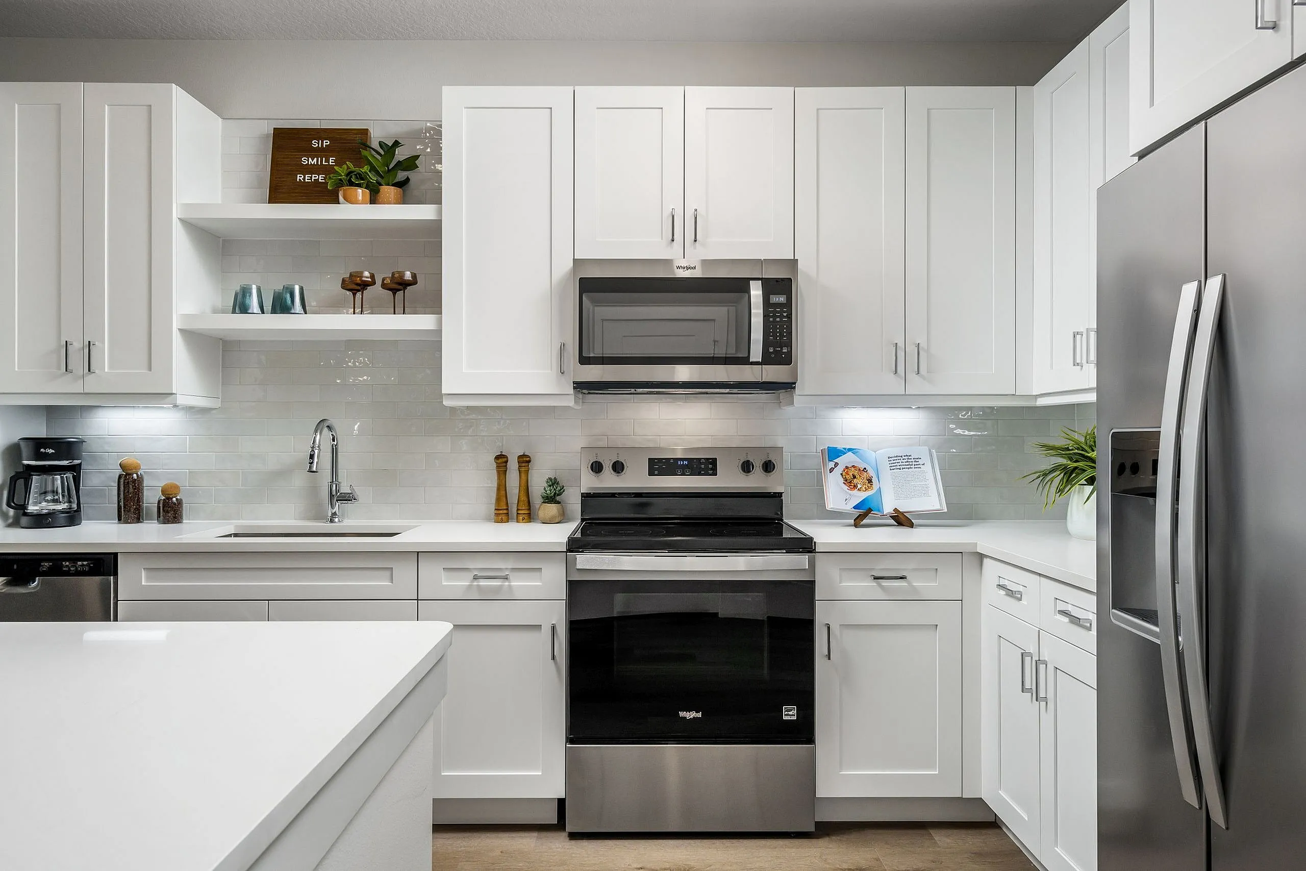 Modern kitchen with sleek white cabinetry, stainless steel appliances, and elegant countertops, creating a bright and inviting cooking space.