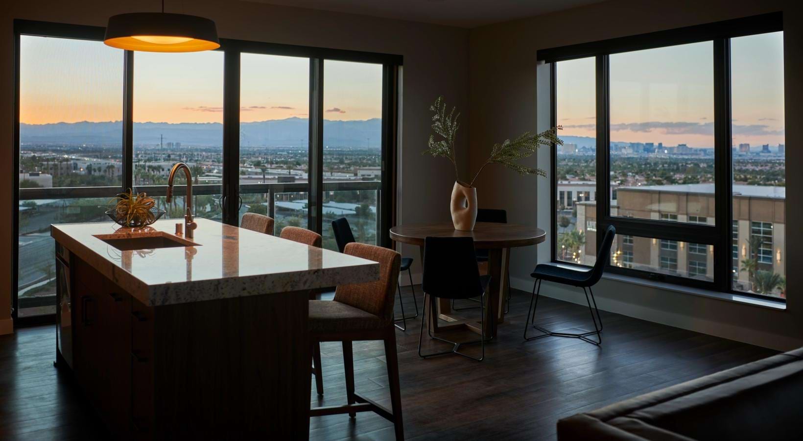 a kitchen and dining room with large windows overlooking a city