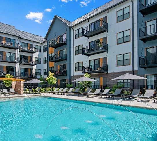 A swimming pool in front of apartment buildings.