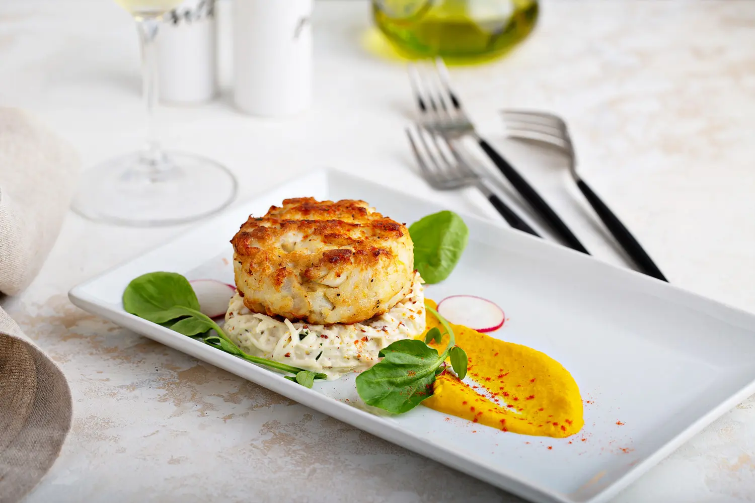 Delicious crab cake served on a bed of seasoned rice, presented in an elegant dining setting