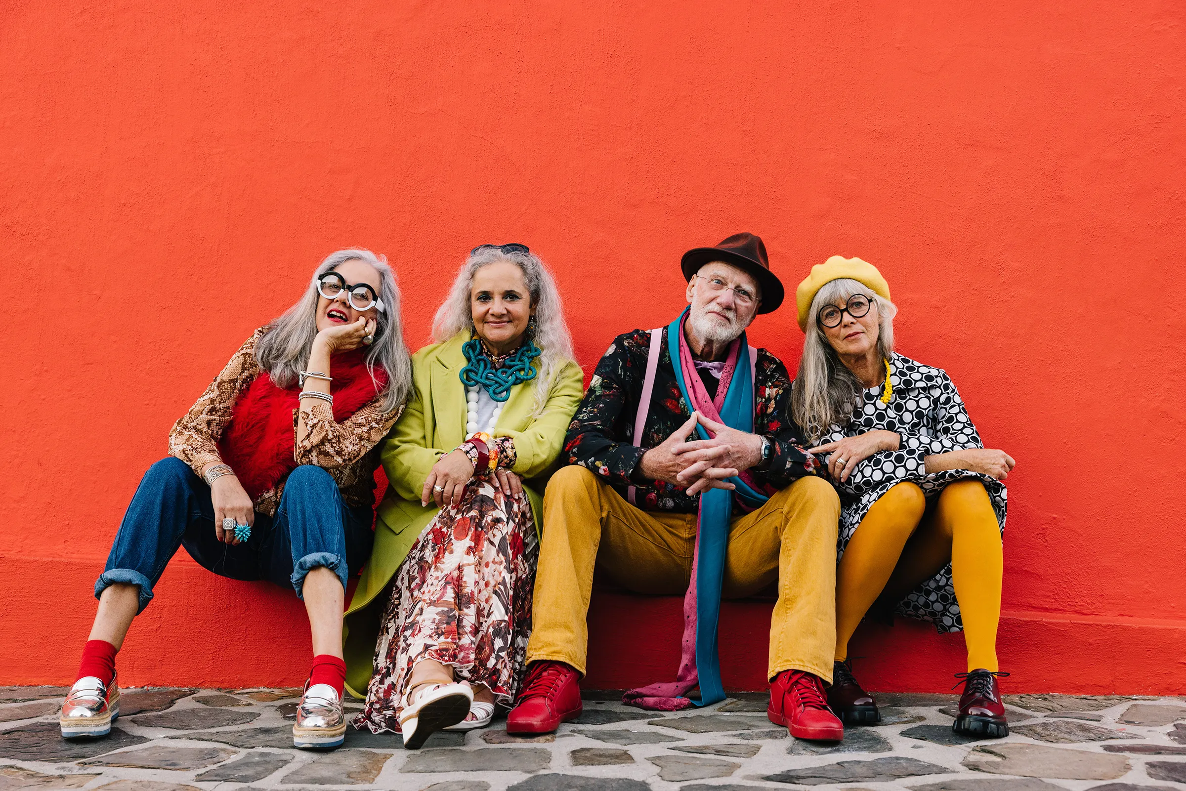group of seniors in vibrant colors sitting down and posing for camera
