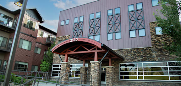 A building with a red roof and a stone pillar in front.