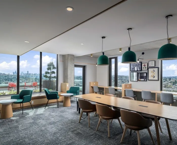 Computer lounge with tables surrounding small and large tables and a view of downtown Seattle