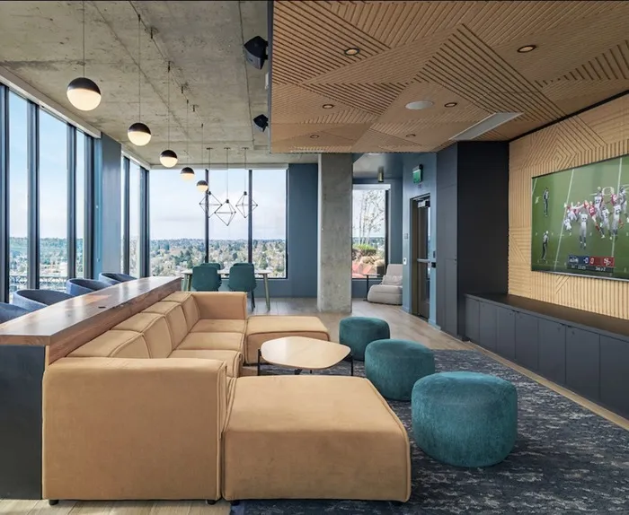 Media lounge with a comfy couch and barstools at The Accolade apartments for rent in Seattle.