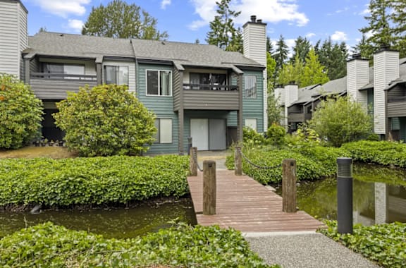 a large house with a pond in front of ii at The Lakes Apartments in Bellevue, Washington, 98007