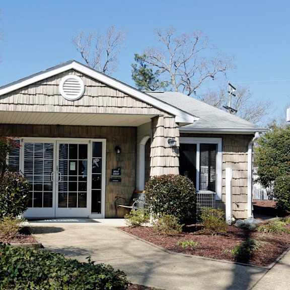 A house with a grey roof and a white fence.