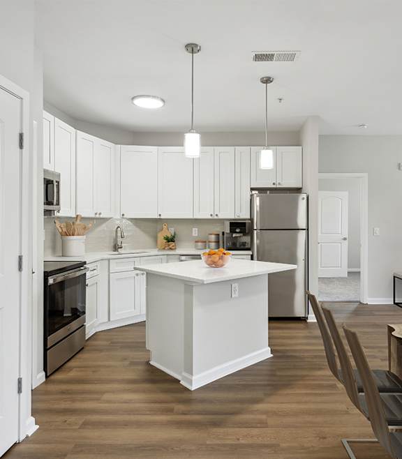 Kitchen and living room with white cabinets and a wooden table at Two Addison Place, Georgia