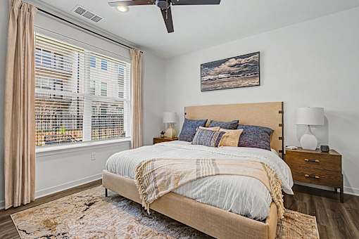 A bedroom with a large bed and a ceiling fan.