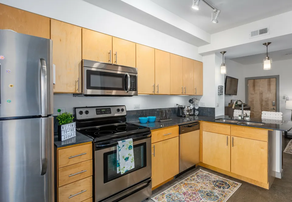 Sleek kitchen with stainless steel appliances, wooden cabinetry, and modern decor.