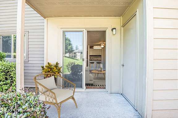 the front porch of a house with a chair and a door at Eagles Landing Apartments, Everett, WA