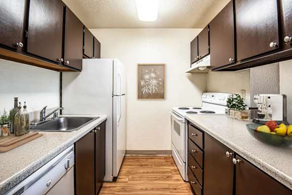 a kitchen with a sink and a refrigerator at Eagles Landing Apartments, Everett, WA