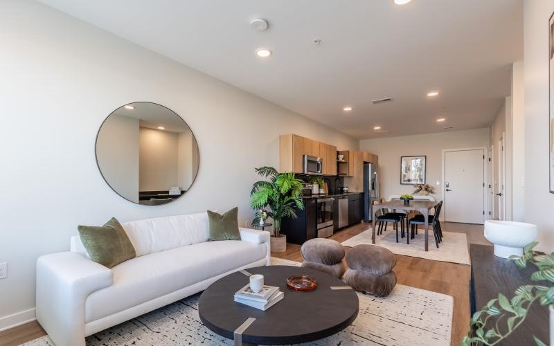a living room with a white couch and a round mirror