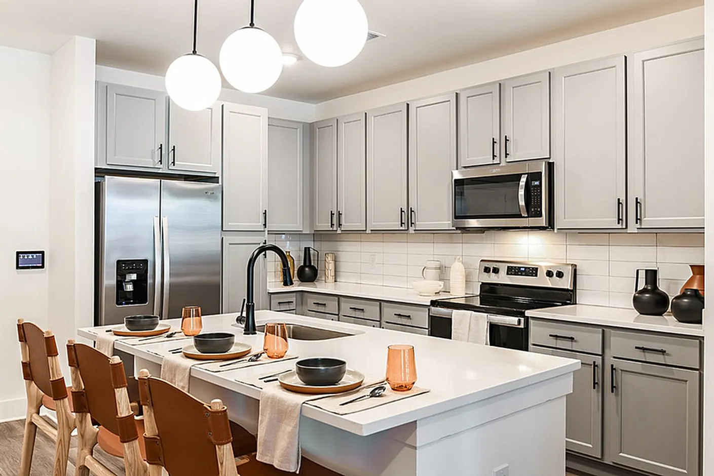 Modern kitchen design featuring sleek grey cabinetry, stainless steel appliances, and an elegant marble island with chic seating.