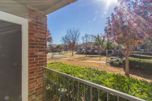 Patio with iron railing overlooking a green space