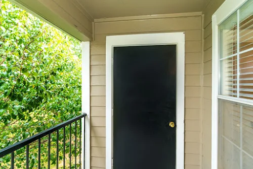 Patio with black iron railing and a black door