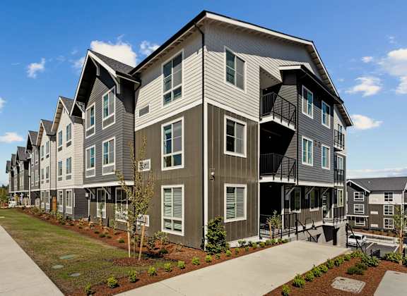 A modern apartment complex with a mix of grey and beige colors.