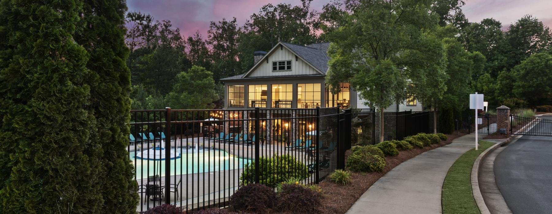 a building with a fence and trees around it