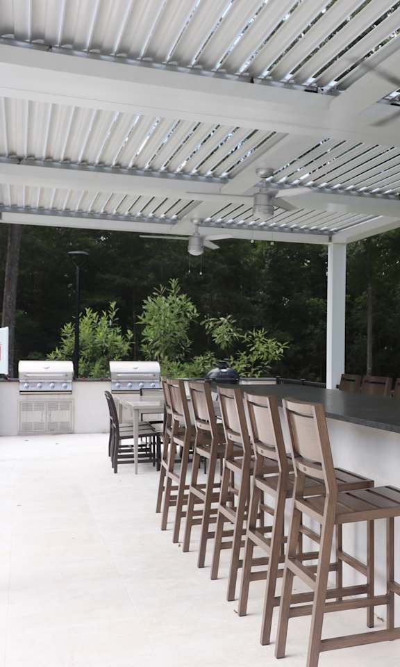 A patio with a bar and chairs.