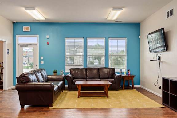 A living room with a brown leather couch and a wooden coffee table.